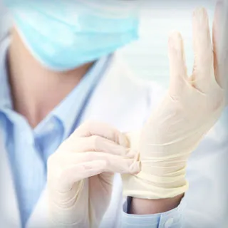 A doctor putting on latex gloves