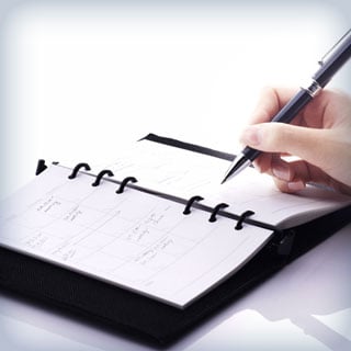 Someone writing in a notebook